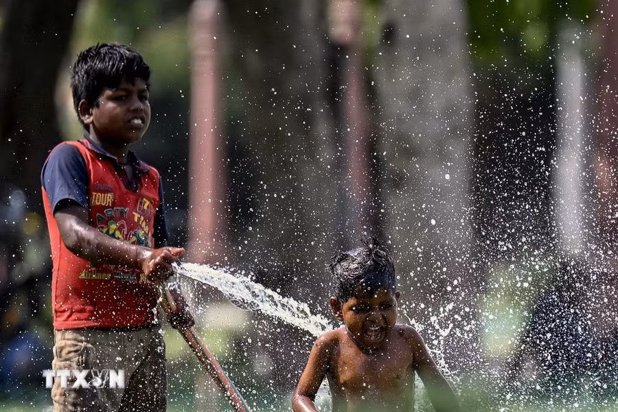 Trẻ em chơi đùa với nước trong ngày nắng nóng tại New Delhi, Ấn Độ, ngày 31/5. (Ảnh: AFP/TTXVN)