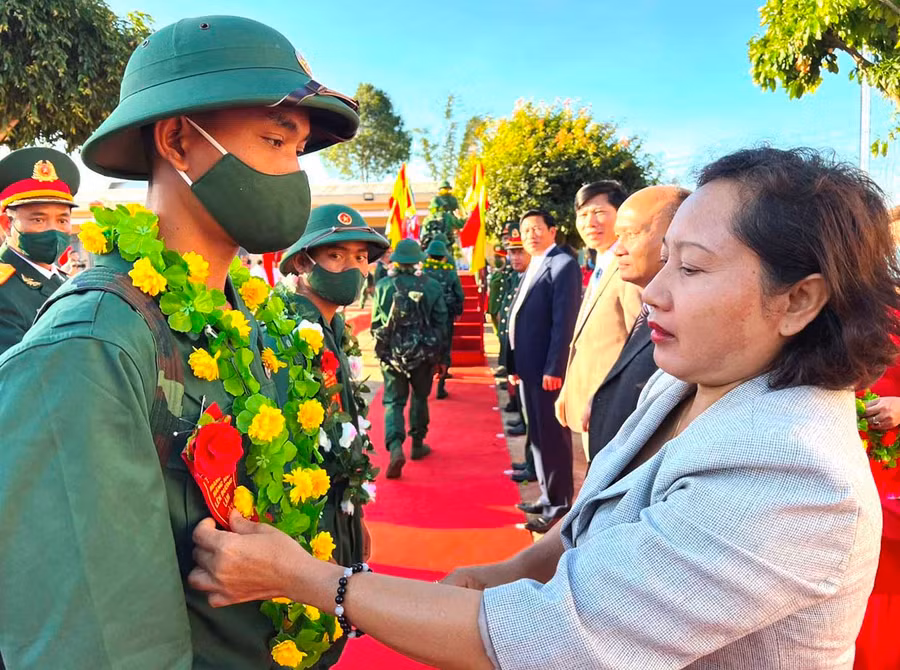 Bà Ayun H'Bút-Tỉnh ủy viên, Phó Chủ tịch HĐND tỉnh trao hoa cho thanh niên huyện Mang Yang trước giờ tòng quân. Ảnh: Đinh Yến