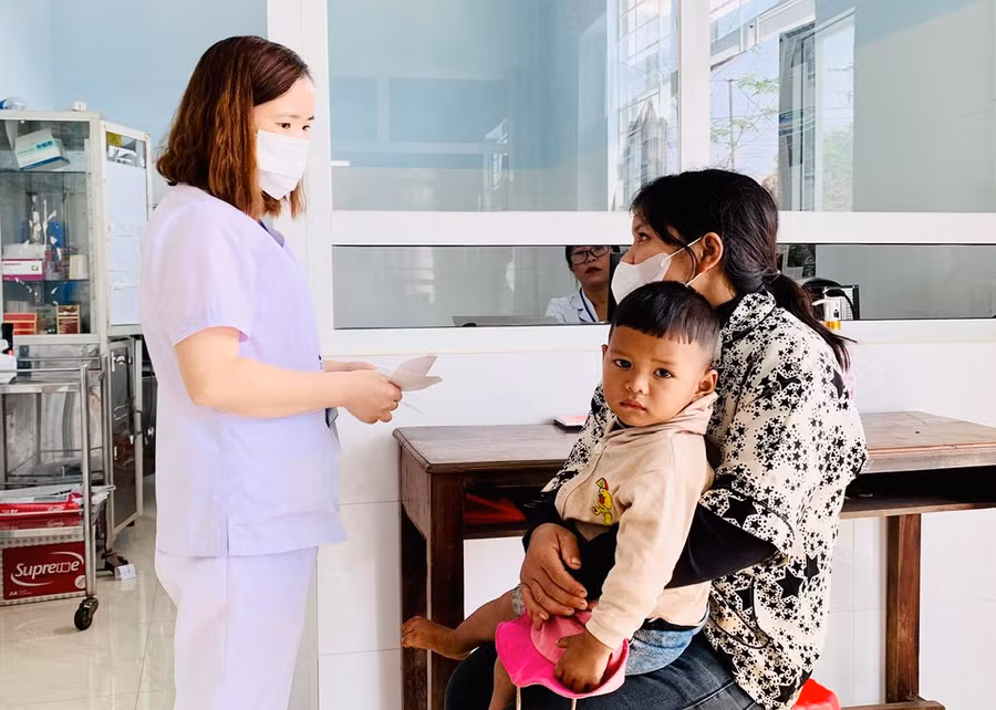 Chị Tai (làng R'Khương-Tleo, xã Kdang, huyện Đak Đoa) đưa con đến Trạm Y tế xã thăm khám sức khỏe. Ảnh: N.N