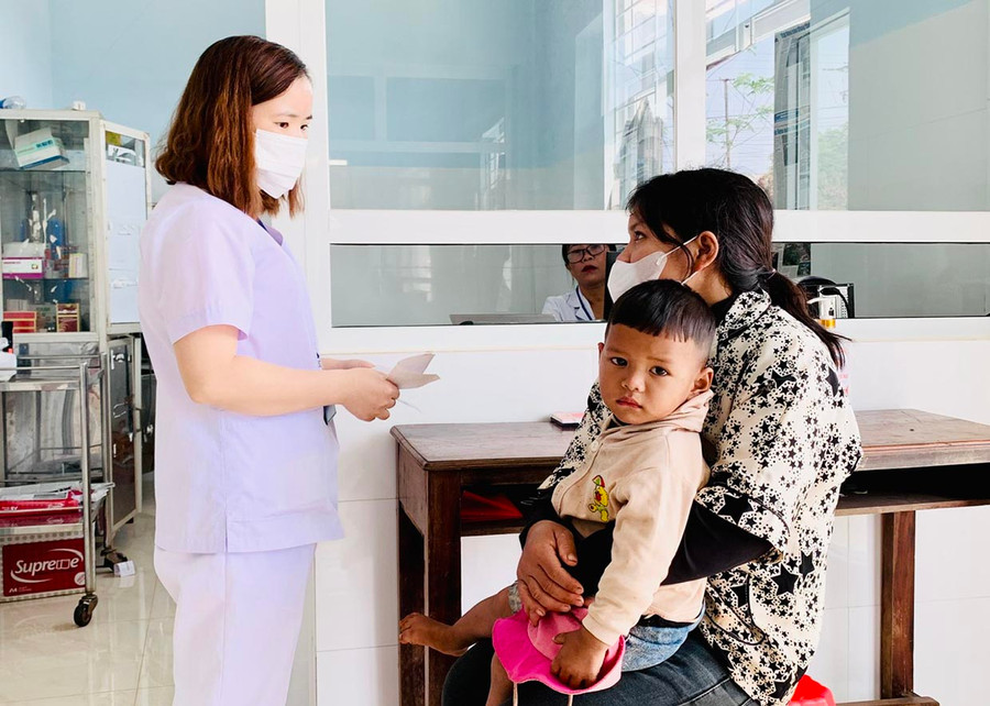 Chị Tai (làng R&apos;Khương-Tleo, xã Kdang, huyện Đak Đoa) đưa con đến Trạm Y tế xã thăm khám sức khỏe. Ảnh: N.N