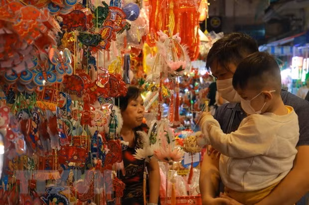 Nhiều gia đình cho trẻ em tới vui chơi và chọn lồng đèn cho dịp Trung thu sắp tới. (Ảnh: Thu Hương/TTXVN)