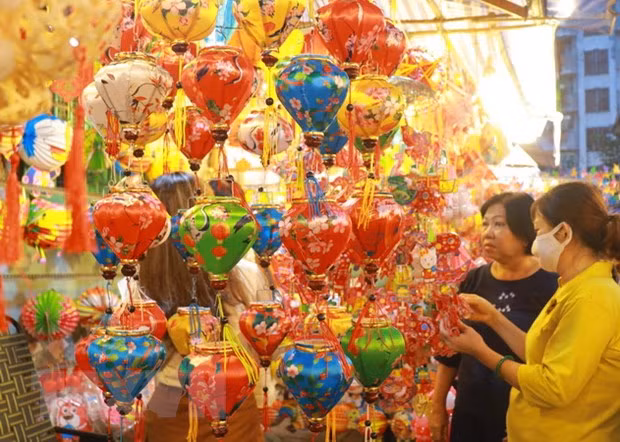 Người dân lựa chọn các mẫu lồng đèn về trang trí cho căn nhà. (Ảnh: Thu Hương/TTXVN)