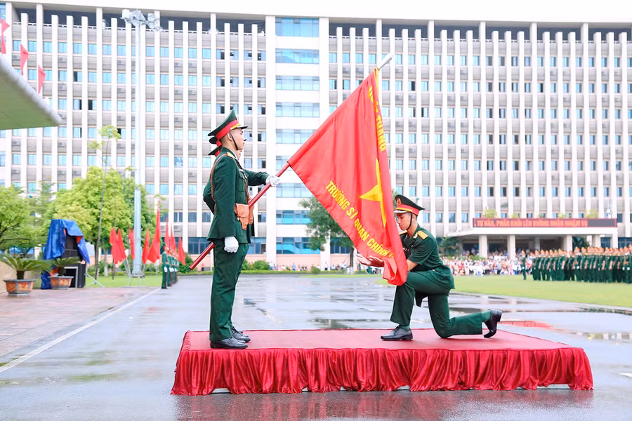 Lê Văn Trường đại diện cho học viên toàn khóa 2019-2024 hôn lên hồng kỳ tại lễ tốt nghiệp (ảnh nhân vật cung cấp).