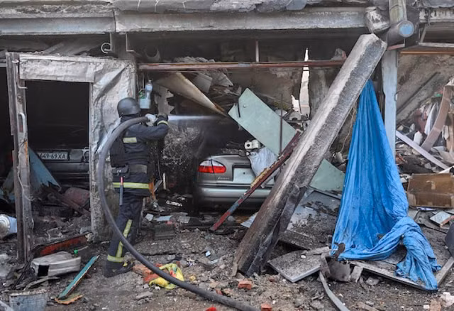 Lực lượng cứu hộ Ukraine làm việc tại hiện trường xảy ra vụ không kích của Nga vào Kharkov. Ảnh: Reuters