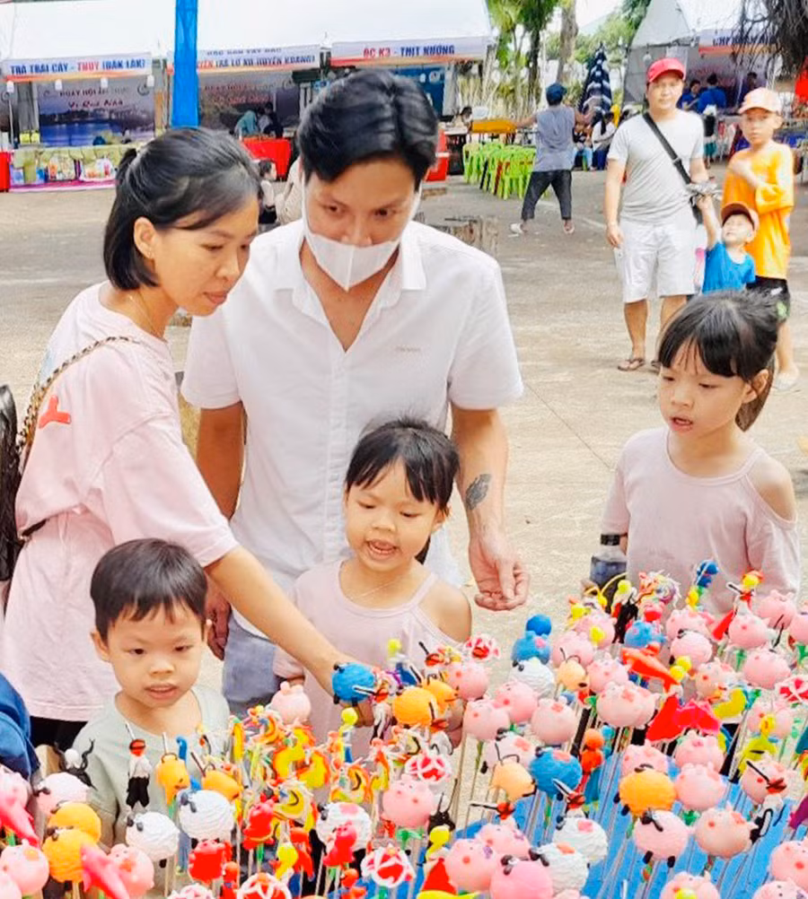 Người dân và du khách thích thú với hình thù ngộ nghĩnh của những chiếc tò he do chính tay anh Mừng nhào nặn. Ảnh Mai Ka