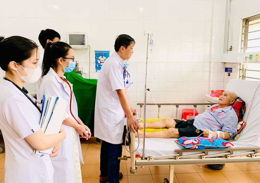 Bác sĩ Trần Kế Toán-Trưởng khoa Tim mạch thăm khám, động viên bệnh nhân đang điều trị tại khoa. Ảnh: Như Nguyện