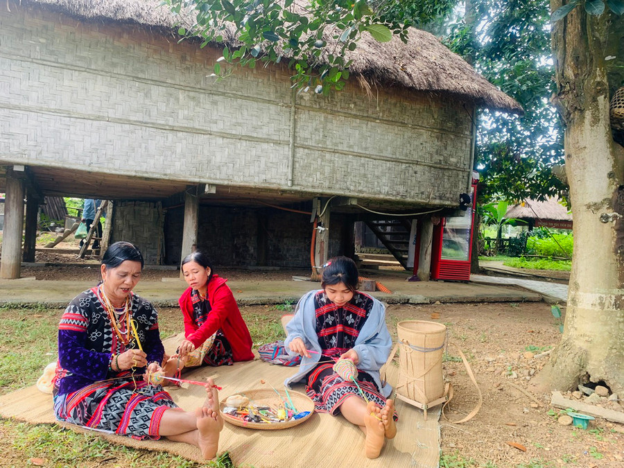 Cô Trần Thị Ram đan vợt cùng mọi người tại khu làng Jrai. Ảnh: Võ Thanh Thảo