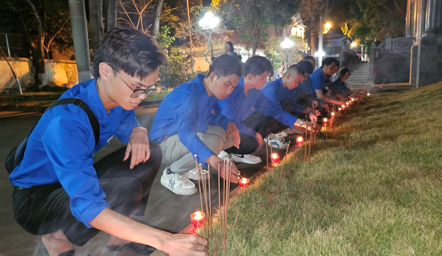 Đoàn viên thanh niên thắp nến tri ân các liệt sĩ tại Di tích lịch sử Đền tưởng niệm mộ liệt sĩ Hội Phú. Ảnh: Phương Dung