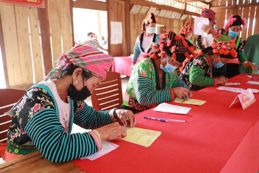 Cử tri người Mông tại bản Nậm Giắt, xã Phỏng Lái, huyện Thuận Châu, tỉnh Sơn La làm thủ tục bỏ phiếu bầu cử đại biểu Quốc hội và Hội đồng Nhân dân các cấp. (Ảnh: Hữu Quyết/TTXVN)