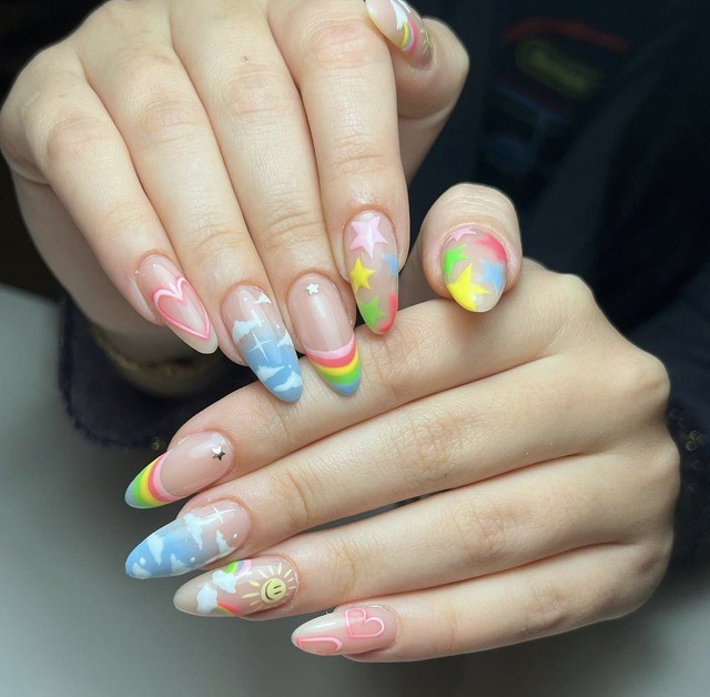 Không chỉ có trang phục hay các phong cách trang điểm mà nhờ các mẫu nail, bạn cũng có thể trẻ trung hơn đến vài tuổi. Nếu không tin, hãy thử trải nghiệm với bộ nail vẽ hình đám mây, cầu vồng, bầu trời và ngôi sao nhiều màu này.