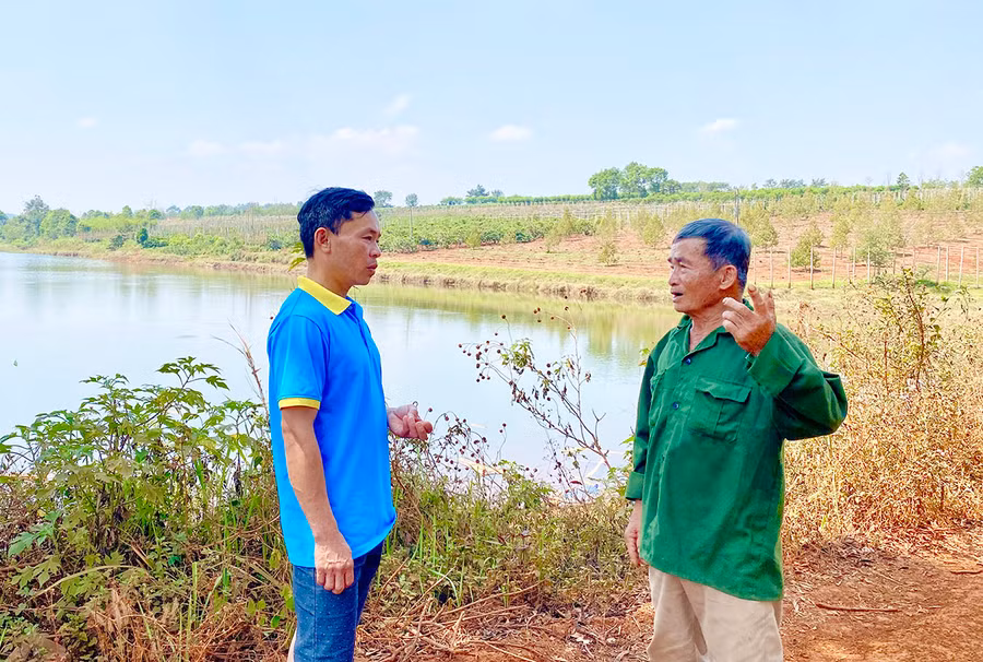 Ông Trần Đình Bông (bìa phải) bên “hồ ba Bông”-nguồn nước tưới cho hàng ngàn héc ta cà phê, sầu riêng ở khu vực này. Ảnh: H.D