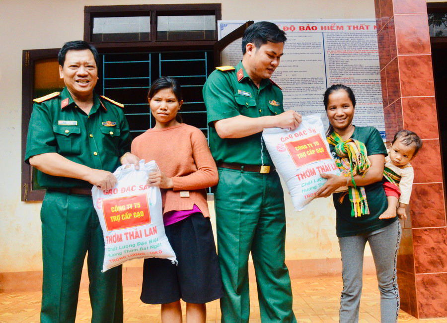 Cán bộ Công ty 75 hỗ trợ gạo cho người dân tộc thiểu số ở làng Lang, xã Ia Dơk, huyện Đức Cơ. Ảnh: Lê Quang Hồi