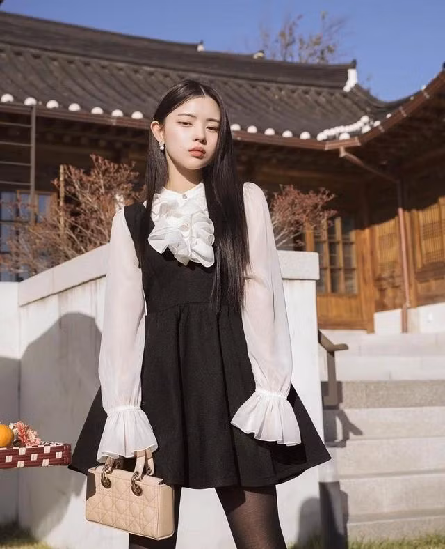 Với tông màu đen chủ đạo, thiết kế baby doll trẻ trung nhưng không kém phần nữ tính và sang chảnh. Ngoài ra, mẫu váy còn trở nên đặc biệt hơn với điểm nhấn tương phản khi được phối cùng áo blouse viền bèo xuyên thấu. Sắc trắng tinh khôi và sắc đen huyền bí tạo cảm giác hài hòa, mang đầy đủ nét đẹp của mỗi cô gái. Bộ trang phục sẽ giúp quý cô nổi bật và thu hút mọi ánh nhìn từ lần đầu gặp gỡ, bên cạnh đó còn mang đến sự nhã nhặn nhưng đầy tính nữ như nàng tiểu thư sang trọng, nền nã