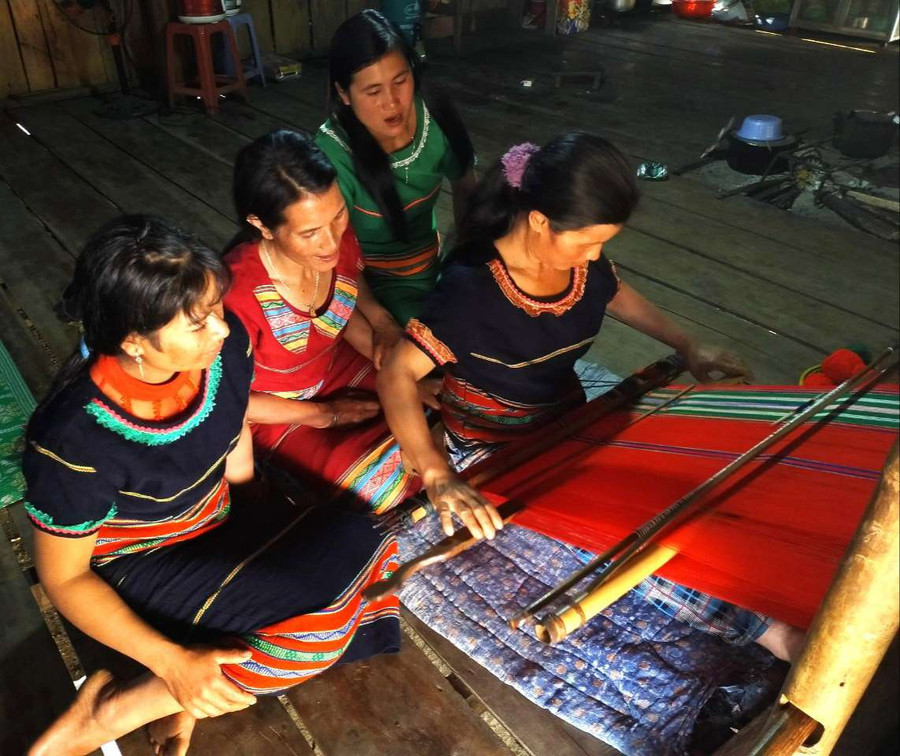 Chị Y Hlạng hướng dẫn các chị em làng Pu Tá dệt vải góp phần gìn giữ bản sắc văn hóa dân tộc Xơ Đăng. Ảnh: PN