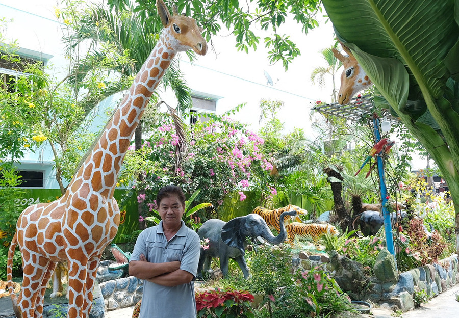 Họa sĩ Trần Quang Lực trong không gian sống rất nhiều loài vật do ông điêu khắc. Ảnh: Minh Châu
