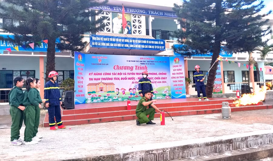 Cán bộ Công an tỉnh Gia Lai hướng dẫn học sinh trên địa bàn thị xã An Khê kỹ năng sử dụng bình chữa cháy. Ảnh: R.H
