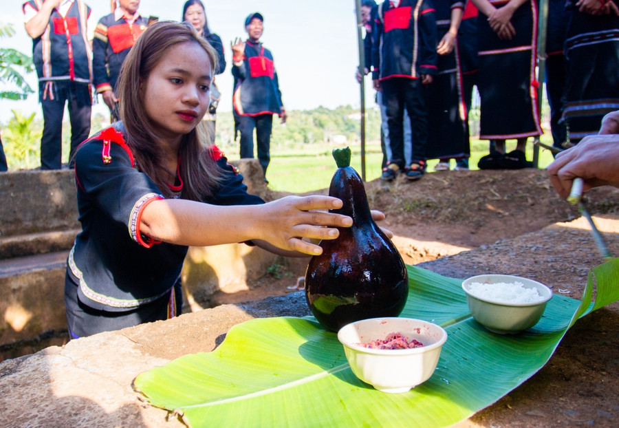 Tại bến nước, khi lễ vật đã sẵn sàng, cô gái lấy một chiếc bầu to nhất hứng đầy nước của bến để chuẩn bị làm lễ.