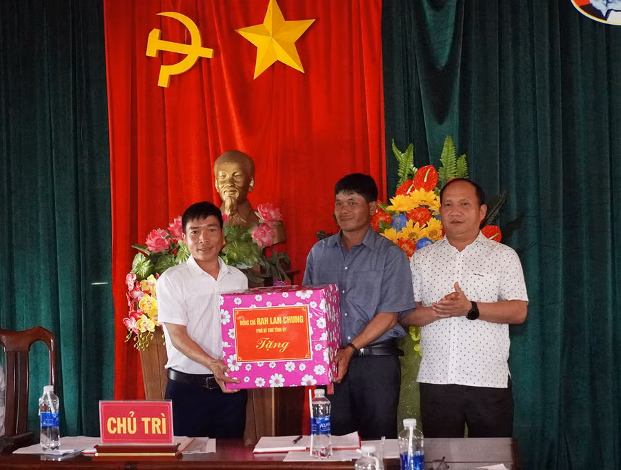 Phó Bí thư Tỉnh ủy Rah Lan Chung (bìa phải) tặng quà cho Chi bộ làng Srắt. Ảnh: Đức Thụy