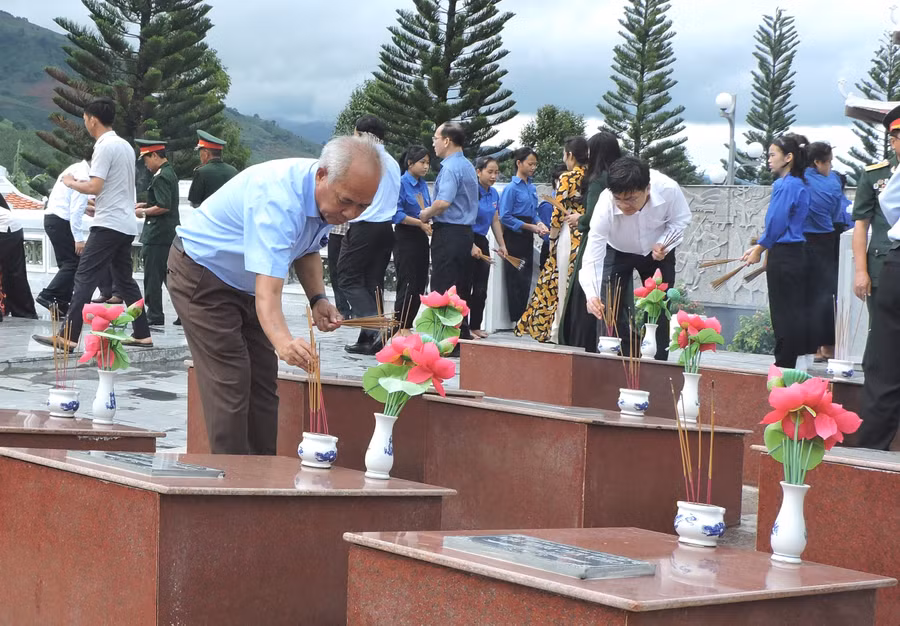 Đồng chí A Pớt - Phó Bí thư Thường trực Tỉnh ủy thắp nén hương thơm lên phần mộ liệt sĩ tại Di tích Điểm cao 995 - Chư Tan Kra. Ảnh: THÙY HƯƠNG