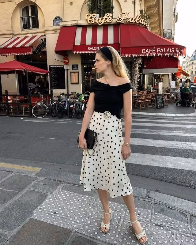 Mặc chân váy dài theo phong cách Chic cùng gợi ý chân váy họa tiết chấm bi, áo kiểu trễ vai, xăng đan họa tiết kèm băng đô lụa/ nhung màu đen gợi nhớ hình ảnh thanh lịch cổ điển. Ảnh Elodieromy