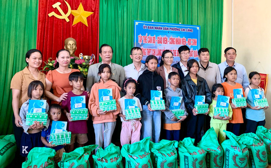 Bà Trần Thị Út (hàng sau, thứ 4 từ phải sang) chụp ảnh lưu niệm cùng các Mạnh Thường Quân trong buổi trao tặng thẻ BHYT cho các em học sinh khó khăn. Ảnh: N.N