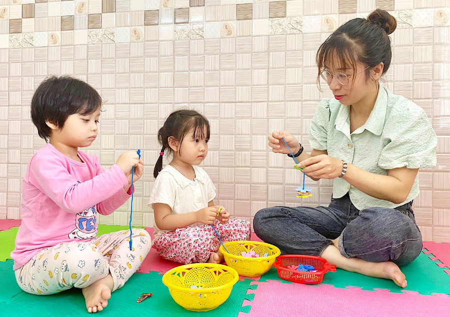 Cô Nguyễn Thị Minh Nguyệt-giáo viên Trường Mầm non Hoàng Mai (phường Hoa Lư, TP Pleiku) hướng dẫn trẻ xâu hoa vào dây. Ảnh: Mộc Trà Cô Nguyễn Thị Minh Nguyệt-giáo viên Trường Mầm non Hoàng Mai (phường Hoa Lư, TP Pleiku) hướng dẫn trẻ xâu hoa vào dây. Ảnh: Mộc Trà