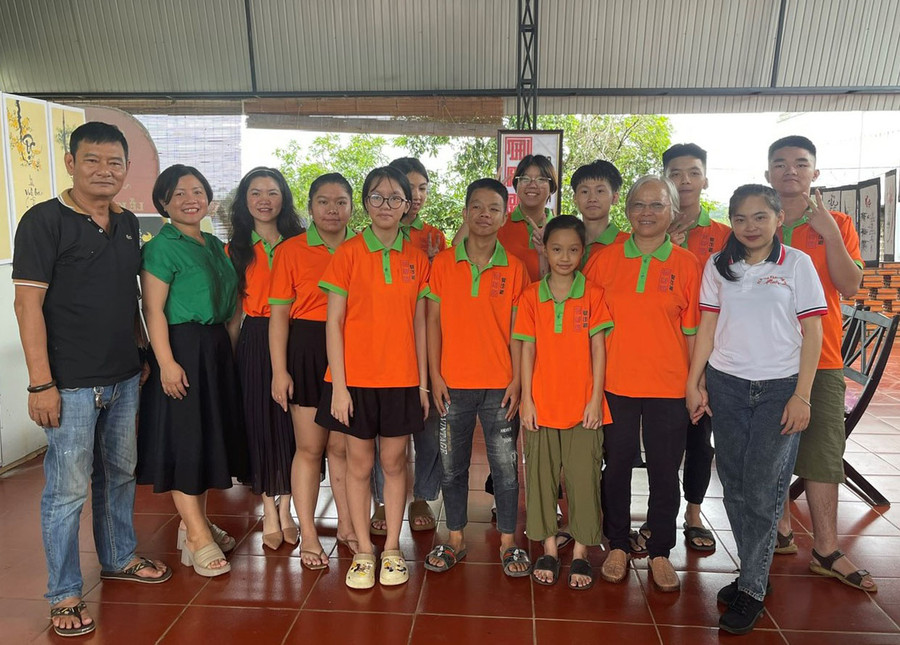 Anh Trần Ngọc Dũng (bên trái)-người hướng dẫn các thành viên CLB Thư pháp Chữ Việt Pleiku chụp hình cùng các cô giáo và các em học sinh lớp học. Ảnh: P.D Anh Trần Ngọc Dũng (bên trái)-người hướng dẫn các thành viên CLB Thư pháp Chữ Việt Pleiku chụp hình cùng các cô giáo và các em học sinh lớp học. Ảnh: P.D