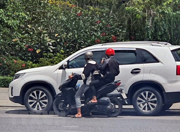 Hai đối tượng dán tờ rơi có nội dung khiêu dâm trên kính xe ôtô. (Ảnh: TTXVN phát) Hai đối tượng dán tờ rơi có nội dung khiêu dâm trên kính xe ôtô. (Ảnh: TTXVN phát)