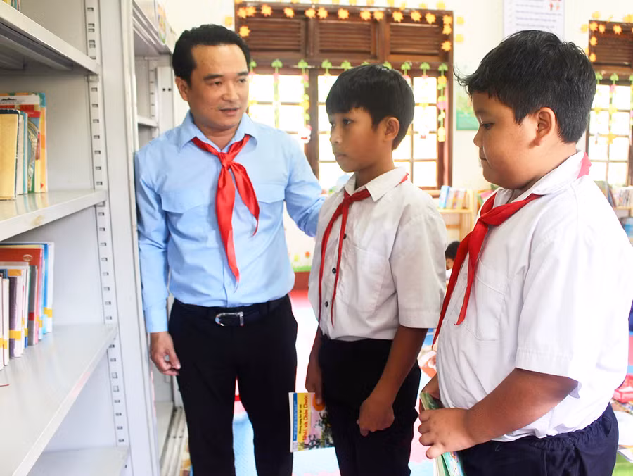Anh Đỗ Duy Nam (bìa trái)-Phó Bí thư Tỉnh Đoàn động viên các em học sinh Trường Tiểu học Ayun số 2 tích cực đọc sách để nâng cao kiến thức. Ảnh: Phan Lài