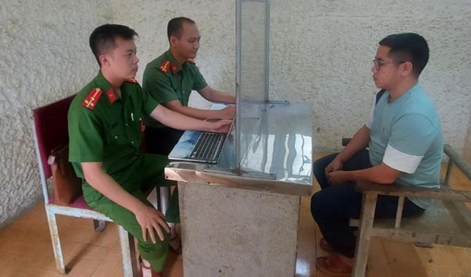 Công an tỉnh Hà Tĩnh lấy lời khai đối tượng Đinh Quốc Tuấn, thành viên một băng nhóm giả danh ngân hàng, công ty cho vay tài chính để lừa đảo. Ảnh: DƯƠNG QUANG