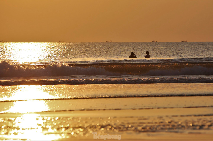 Dọc dải biển yên bình, người dân, du khách tranh thủ thức dậy ngắm bình minh, tắm dưới làn nước mát lạnh.