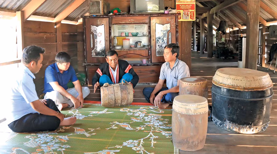 Nghệ nhân Kpă Bưn (thứ 2 từ phải sang) chia sẻ cách sử dụng từng loại trống. Ảnh: P.L