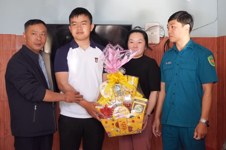 Ông Nguyễn Tín (bìa trái)-Chủ tịch UBND phường Diên Hồng (TP. Pleiku) tặng quà động viên gia đình thanh niên Nguyễn Hữu Xuân. Ảnh: Q.T