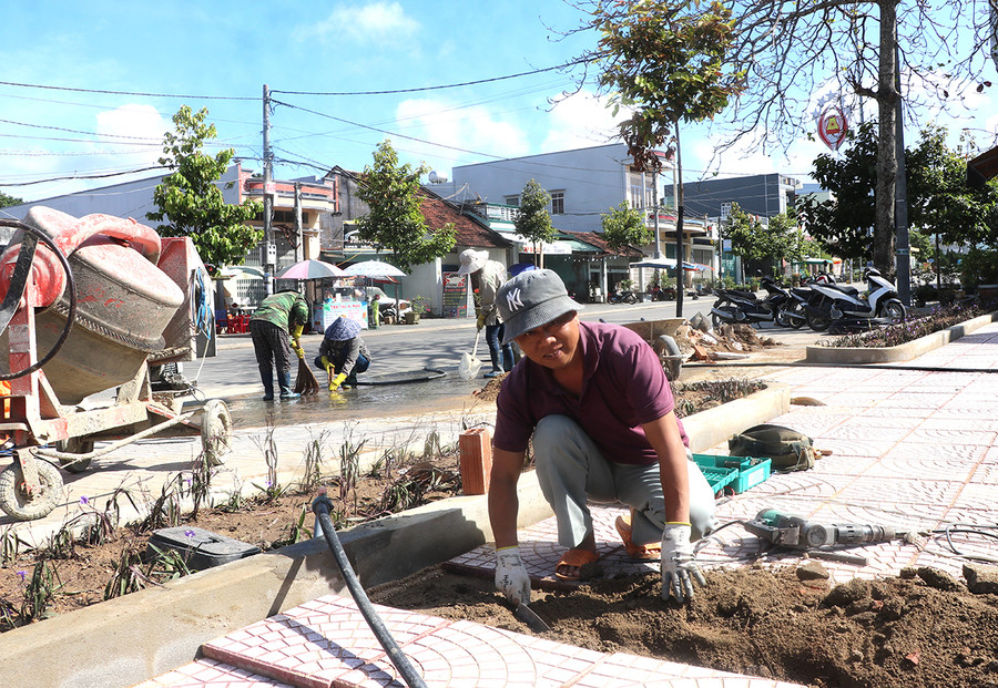 Công nhân đang hoàn tất các công đoạn cuối cùng công trình xây dựng bồn hoa, lát gạch vỉa hè tại khu vực ngã năm Đỗ Trạc-nơi lắp đặt 2 biểu tượng linh vật Giáp Thìn 2024. Ảnh: A.P