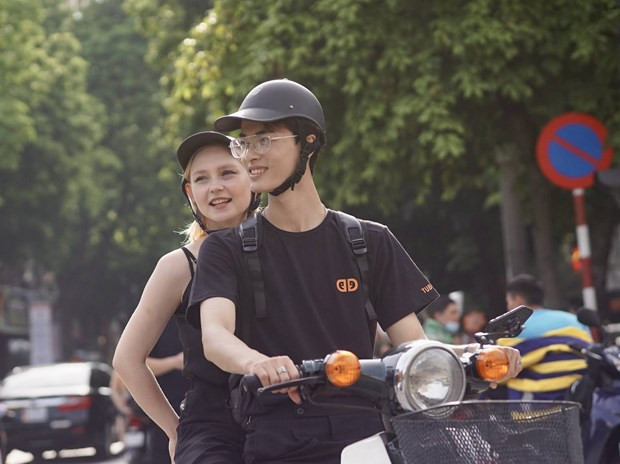 Du khách quốc tế thích thú trải nghiệm Hà Nội bằng xe gắn máy. (Ảnh: PV/Vietnam+)