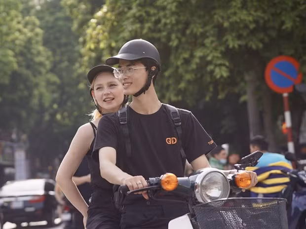 Du khách quốc tế thích thú trải nghiệm Hà Nội bằng xe gắn máy. (Ảnh: PV/Vietnam+)