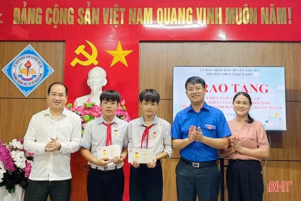 Bí thư Huyện ủy Lộc Hà Nguyễn Thế Hoàn cùng đại diện Tỉnh đoàn Hà Tĩnh trao Huy hiệu Tuổi trẻ dũng cảm của Trung ương Đoàn cho 2 học sinh tham gia cứu 2 em nhỏ bị đuối nước. (Nguồn: Báo Hà Tĩnh)