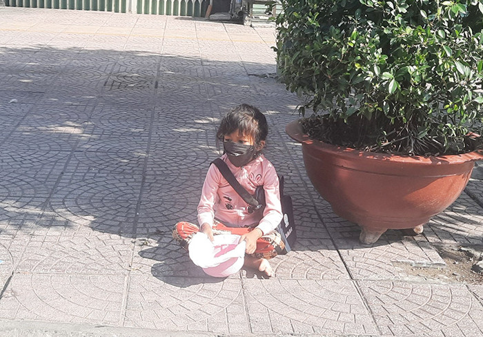 Em bé 5 tuổi phơi nắng ngoài đường đi xin.