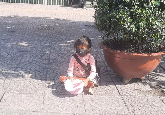 Em bé 5 tuổi phơi nắng ngoài đường đi xin.