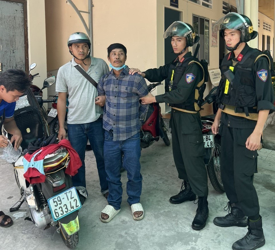 Đối tượng Trương Văn Út (áo sọc đen) bị tạm giữ vì liên quan đến vụ án giết người. (Ảnh: TTXVN phát)