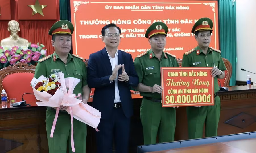 Ông Hồ Văn Mười, Chủ tịch UBND tỉnh Đắk Nông thưởng nóng Công an tỉnh Đắk Nông về thành tích phá nhanh vụ án. (Ảnh: TTXVN phát)