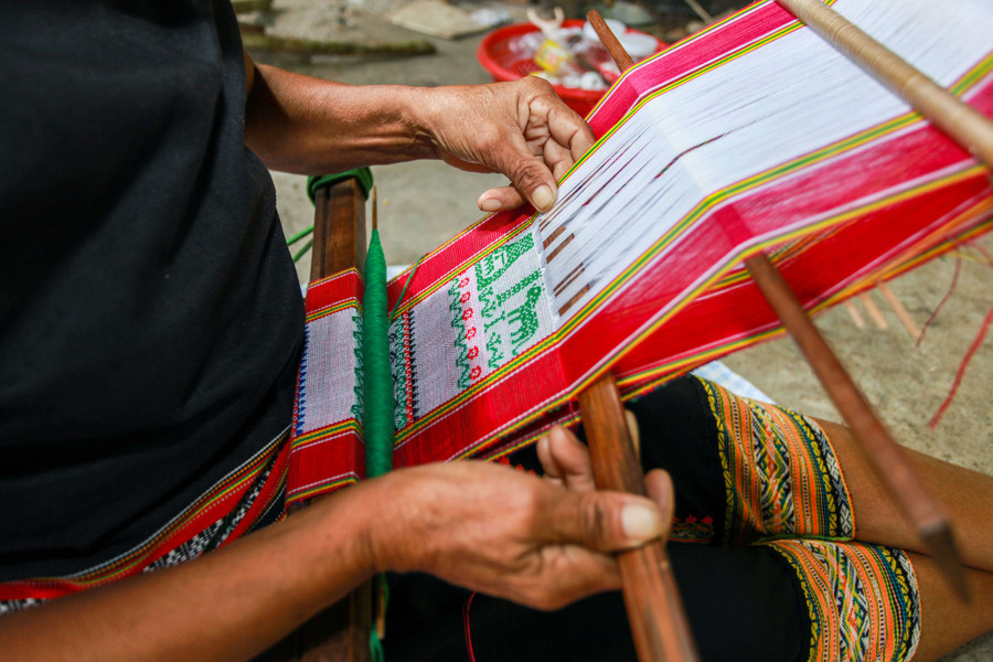 Nghệ nhân Y Yin đang dệt những phân cảnh kể chuyện trên thổ cẩm. Ảnh: H.T