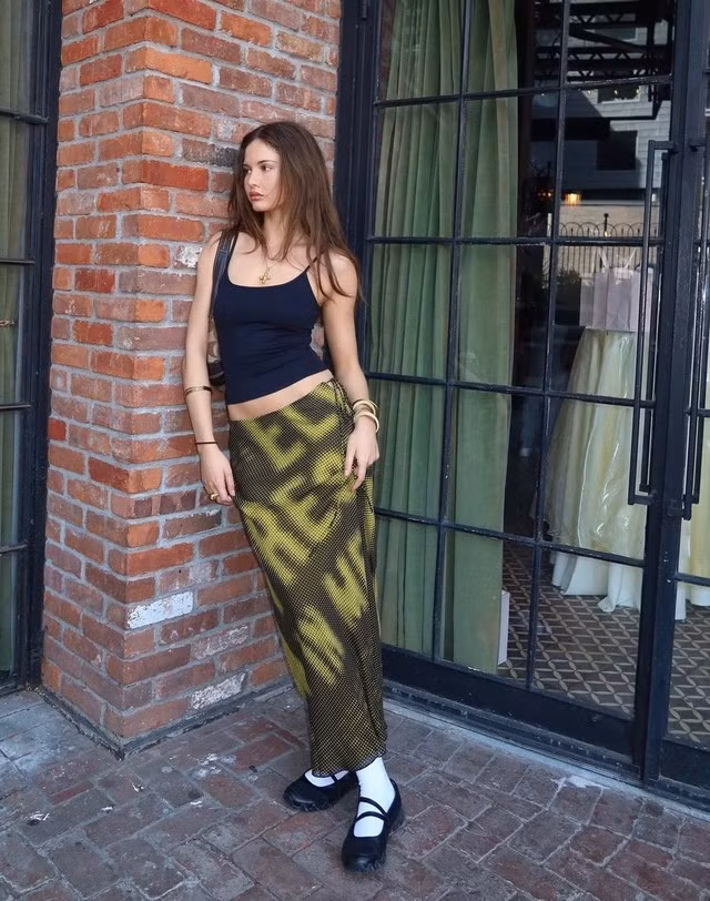 Nếu vẫn còn lăn tăn trong việc mix đồ với chân váy maxi bạn có thể tham khảo công thức phối đồ của cô nàng Ruby Lyn bằng bản phối áo hai dây mix cùng chân váy maxi họa tiết. Cô tạo điểm nhấn cho vẻ ngoài bằng đôi giày Mary Jane và tất lỡ màu trắng