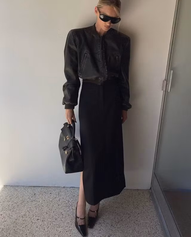 Nếu như chân váy maxi mang cảm giác mềm mại, điệu đà thì áo khoác da lại gợi cảm giác lạnh lùng, sang chảnh. Ngỡ rằng hơi lạc quẻ nhưng thực tế bộ đôi này lại kết hợp ăn ý vô cùng. Chân váy maxi dáng suông xẻ ngang được Elsa Hosk phá cách mix cùng áo khoác bomber mang đến nét thanh lịch tinh tế cho người mặc. Cô hoàn thiện set đồ bằng túi xách và kính thời trang khiến tổng thể nhìn đầy sành điệu