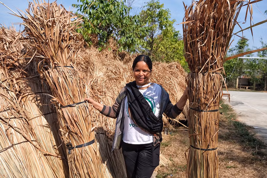 Chị Nhaih vui vẻ khi được góp sức vào công việc chung của làng. Ảnh: Hoàng Ngọc