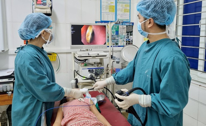 Gắp thành công đồng xu mắc kẹt trong thực quản của bé gái 5 tuổi - Ảnh 1. Các bác sĩ tiến hành gắp đồng xu cho cháu A