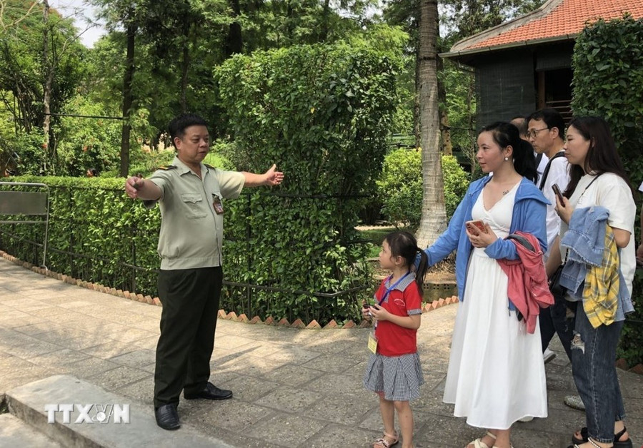 Anh Nguyễn Minh Hà, nhân viên bảo vệ Khu Di tích Nhà sàn Bác Hồ hướng dẫn khách tham quan. (Ảnh: Phương Lan/TTXVN) Anh Nguyễn Minh Hà, nhân viên bảo vệ Khu Di tích Nhà sàn Bác Hồ hướng dẫn khách tham quan. (Ảnh: Phương Lan/TTXVN)