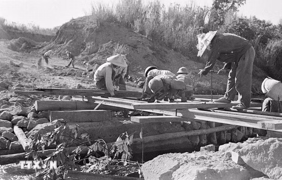 Mặc cho máy bay Mỹ điên cuồng đánh phá, chiến sỹ công binh cầu Đ, Quảng Bình vẫn ngày đêm bám đường, bắc cầu cho xe ra tiền tuyến, đảm bảo mạch máu giao thông giữa hậu phương và tiền tuyến, tháng 8/1968. (Ảnh: Chí Thành/TTXVN) Mặc cho máy bay Mỹ điên cuồng đánh phá, chiến sỹ công binh cầu Đ, Quảng Bình vẫn ngày đêm bám đường, bắc cầu cho xe ra tiền tuyến, đảm bảo mạch máu giao thông giữa hậu phương và tiền tuyến, tháng 8/1968. (Ảnh: Chí Thành/TTXVN)