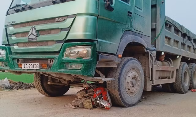Xe máy bị cuốn vào gầm xe tải. Ảnh: C.T.V