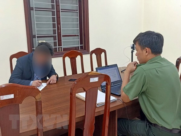 Cơ quan điều tra làm việc với người vi phạm. (Ảnh: Cơ quan Điều tra cung cấp/TTXVN phát)